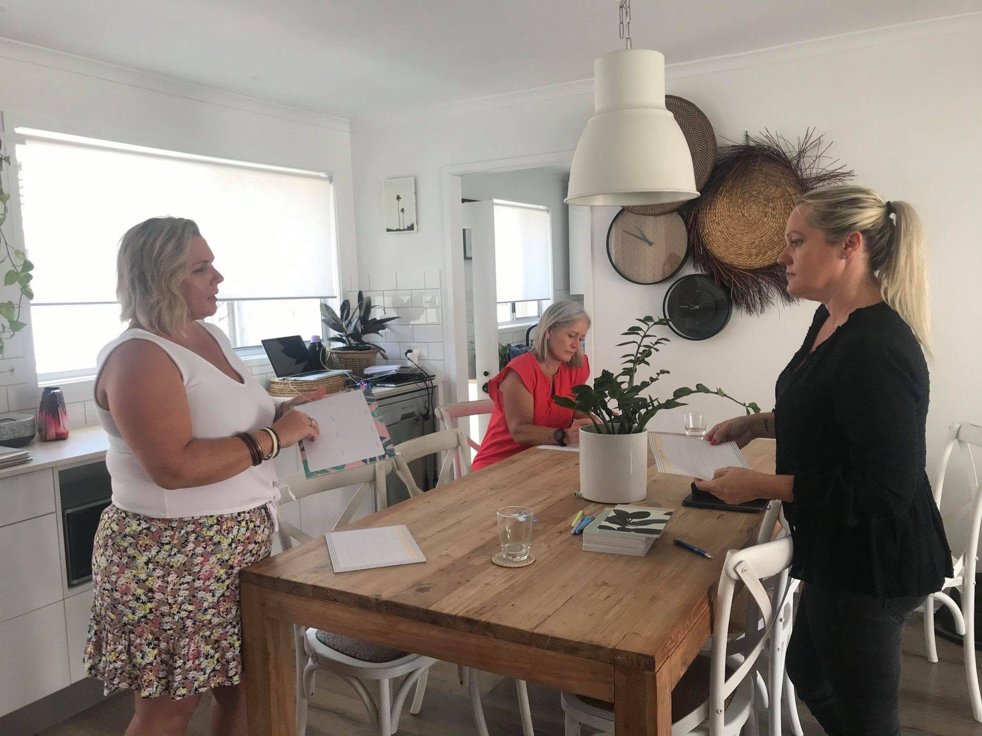 A Quick Fix session around a kitchen table, three women working through planning sheets together.